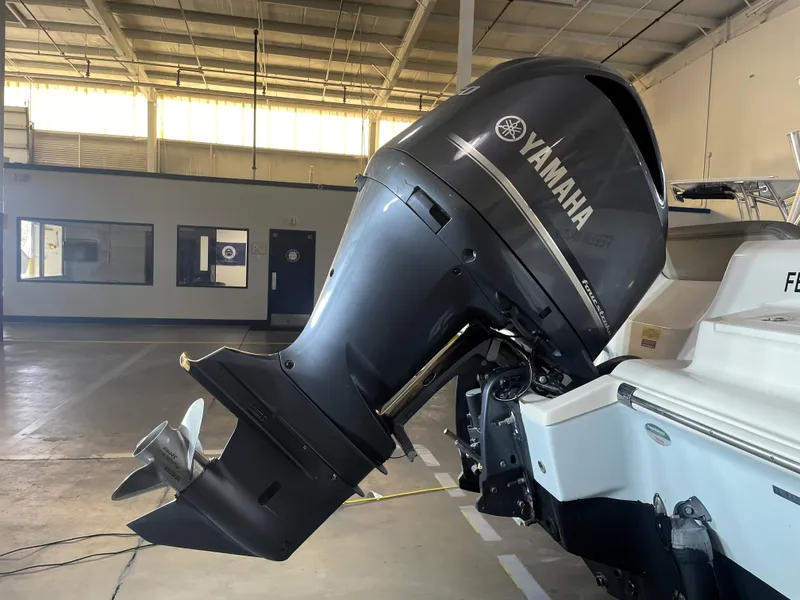 Slide: The Image of 2023 Key West 239 DFS boat in a warehouse, featuring a powerful outboard motor. - 6