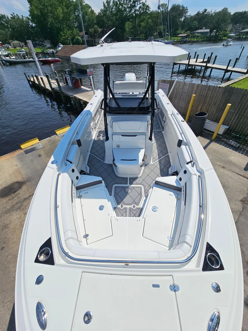 Slide: The Image of 2021 Blackfin 252 CC boat docked, showcasing spacious deck and seating area. - 18