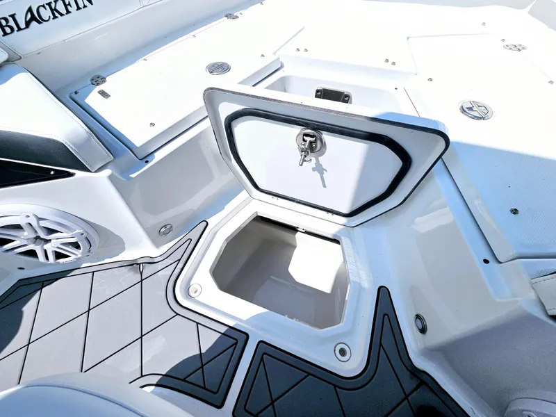 Slide: The Image of 2021 Blackfin 252 CC boat storage compartment with open hatch and key. - 19