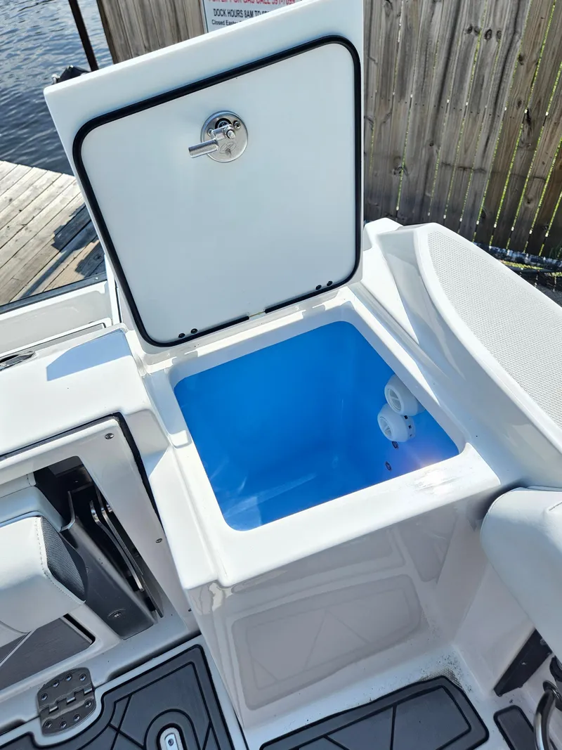 Slide: The Image of 2021 Blackfin 252 CC boat with open storage compartment, dockside view. - 27