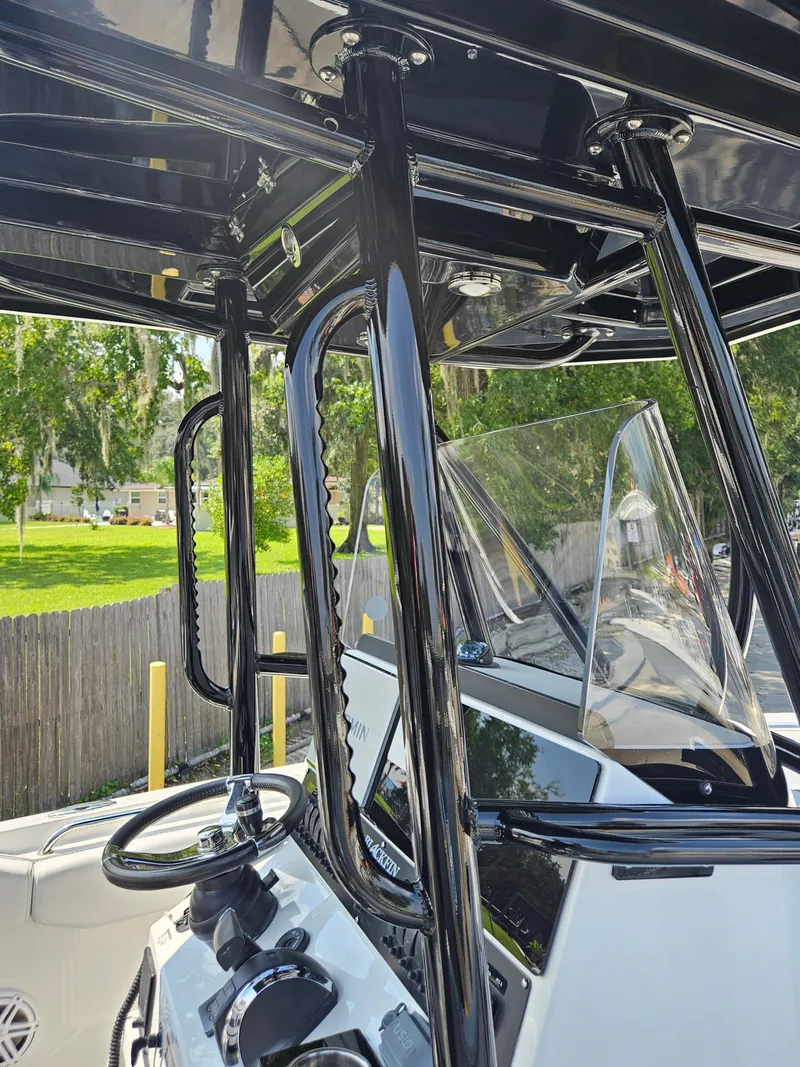 Slide: The Image of 2021 Blackfin 252 CC boat console with sleek black frame and windshield. - 29