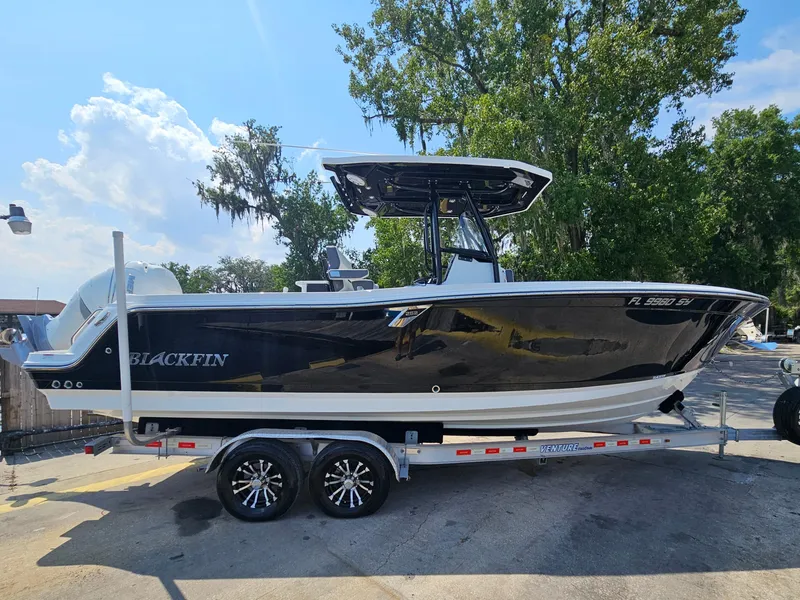 Slide: The Image of 2021 Blackfin 252 CC boat on trailer, parked outdoors, under clear sky. - 3