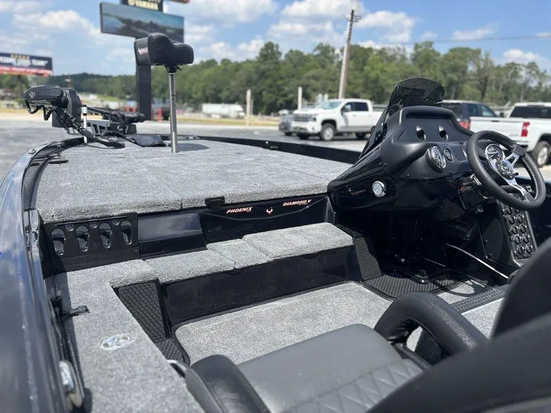 Slide: The Image of 2026 Phoenix 721 ZXL boat interior with steering wheel and seating, parked outdoors. - 14