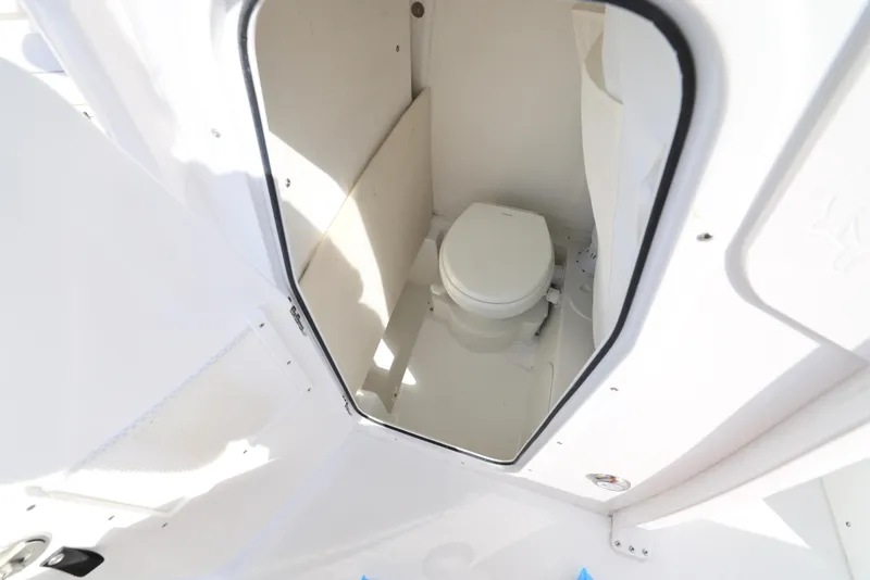 Slide: The Image of 2025 Sea Hunt Ultra 245 SE boat interior with compact marine toilet. - 12
