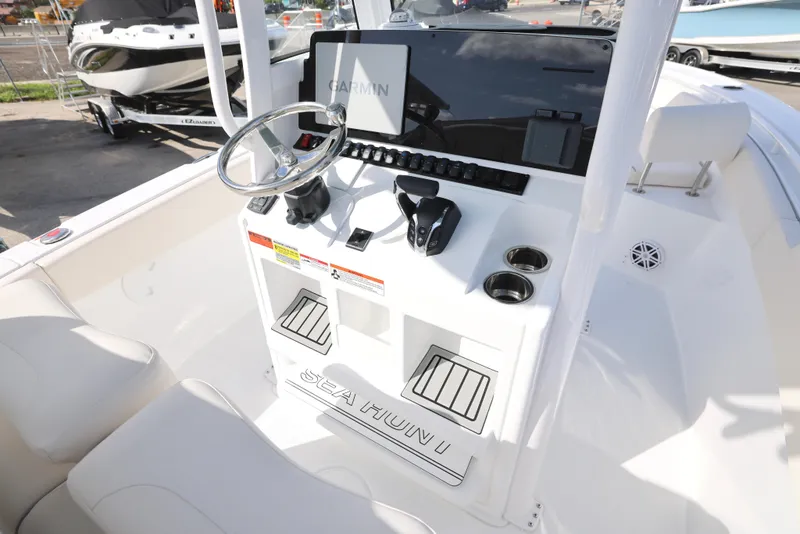 Slide: The Image of 2025 Sea Hunt Ultra 245 SE boat console with steering wheel and controls. - 14