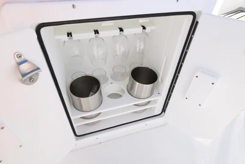 Slide: The Image of 2025 Sea Hunt Ultra 245 SE boat storage with glass holders and stainless steel cups. - 18