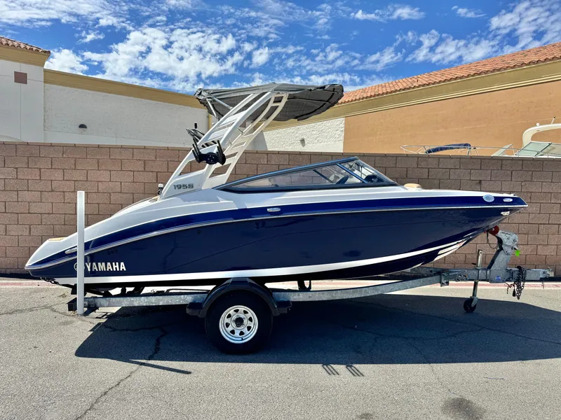 The Image of 2022 Yamaha Boats AR 195 S on trailer, parked outdoors under blue sky. - 0