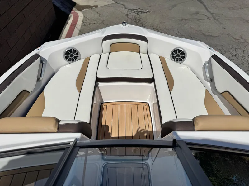 Slide: The Image of 2022 Yamaha Boats AR 195 S interior with tan and white seating, wood flooring. - 10