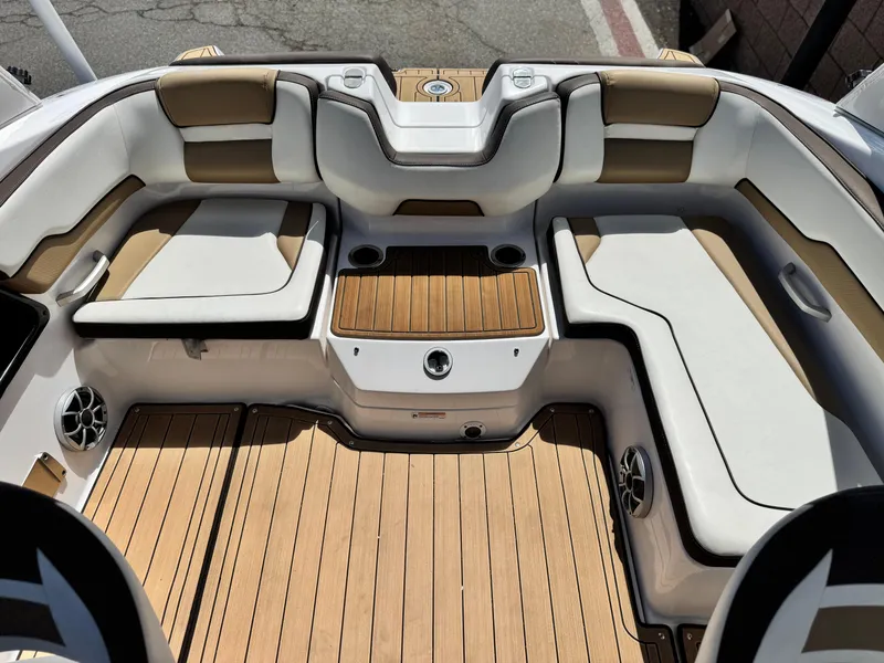 Slide: The Image of 2022 Yamaha Boats AR 195 S interior with cushioned seating and wood-style flooring. - 14