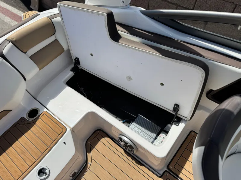 Slide: The Image of 2022 Yamaha Boats AR 195 S interior storage compartment with open lid and teak flooring. - 15