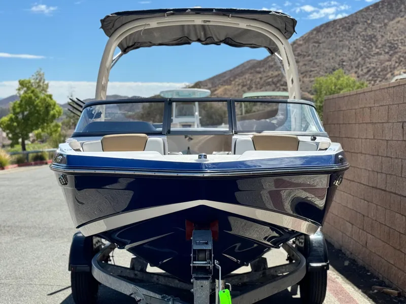 Slide: The Image of 2022 Yamaha Boats AR 195 S on trailer, parked outdoors with scenic mountain backdrop. - 2