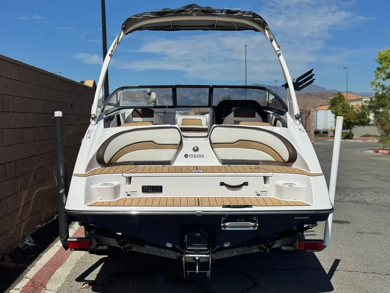Slide: The Image of 2022 Yamaha Boats AR 195 S, rear view, parked outdoors, showcasing seating and deck. - 4