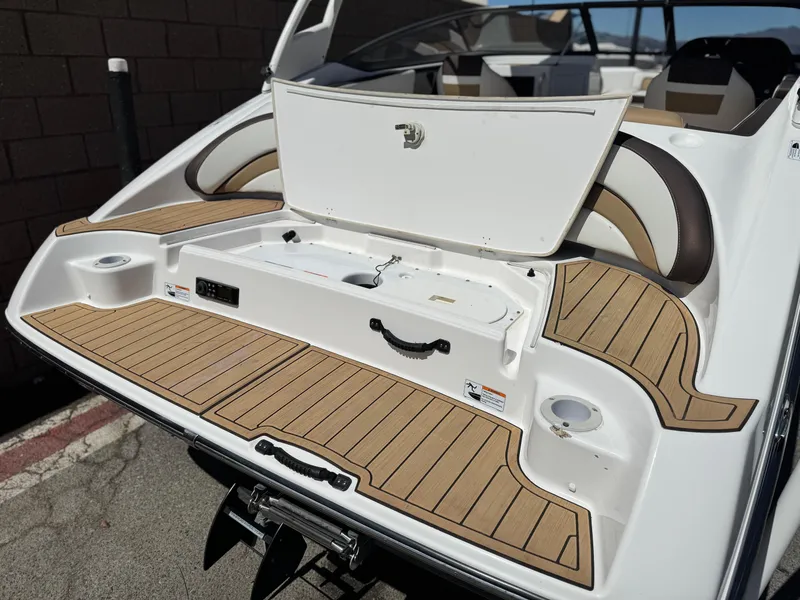 Slide: The Image of 2022 Yamaha Boats AR 195 S with open storage compartment and teak-style deck. - 7