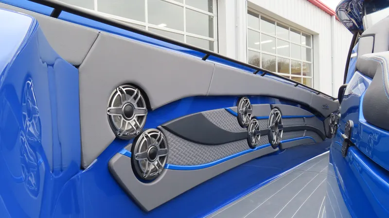 Slide: The Image of Interior of 2025 MTI 42V boat with blue and gray design, featuring multiple speakers. - 13