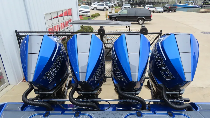 Slide: The Image of Four blue outboard motors on MTI 42V boat, 2025 model, in a parking area. - 26