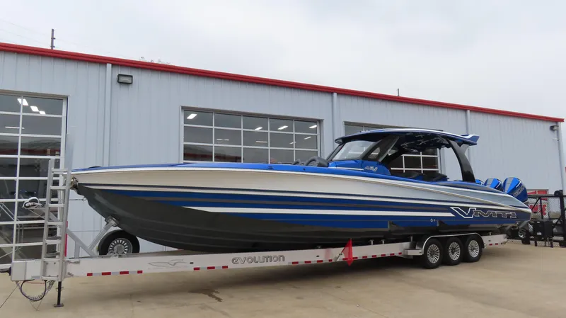 Slide: The Image of 2025 MTI 42V boat on trailer outside a building. - 3