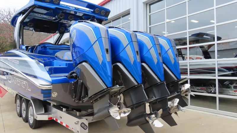 Slide: The Image of Blue MTI 42V boat with four powerful outboard engines, parked near a modern garage. - 5