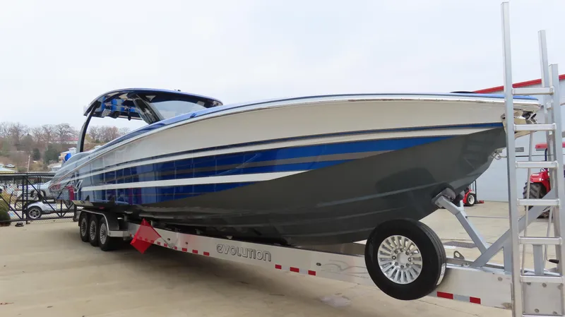 Slide: The Image of 2025 MTI 42V boat on trailer, featuring sleek blue and gray design. - 7