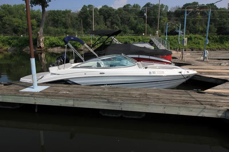 Slide: The Image of 2015 Cruisers Sport Series 238 Bow Rider docked at a marina, surrounded by lush greenery. - 3