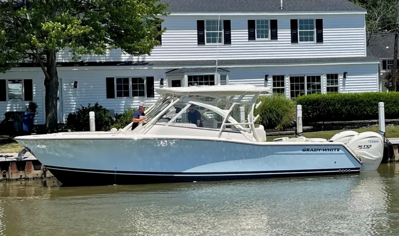 The Image of 2024 Grady-White Freedom 335 boat docked near a white house. - 0