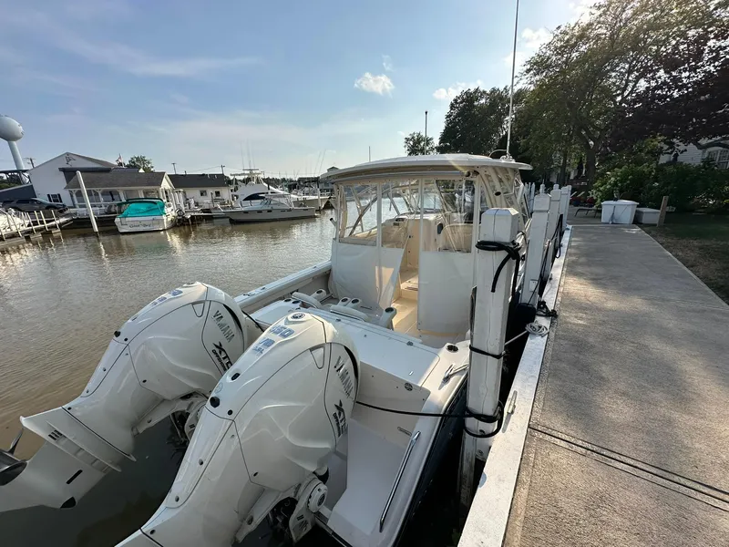 Slide: The Image of 2024 Grady-White Freedom 335 boat docked with dual Yamaha outboard engines. - 2