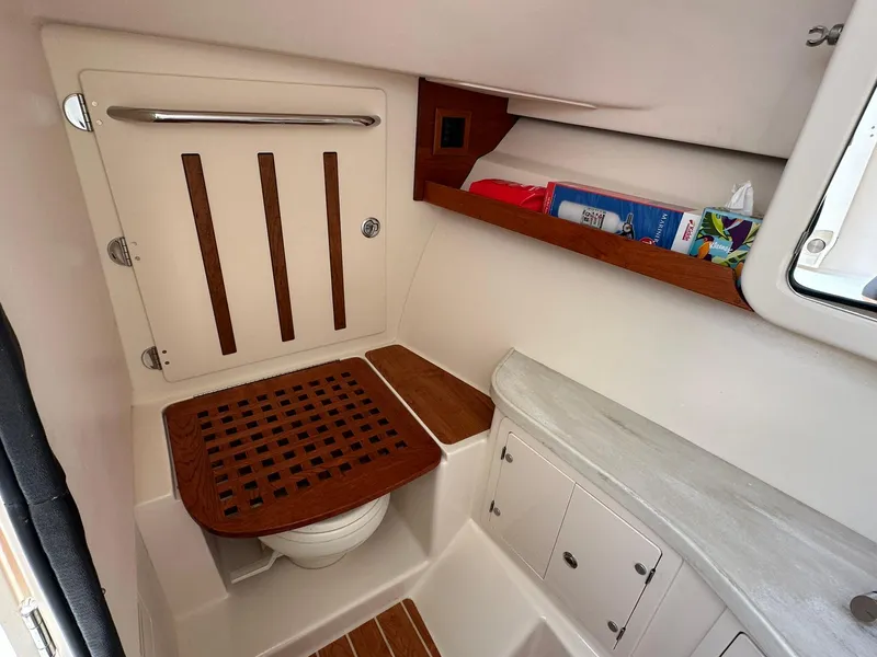 Slide: The Image of 2024 Grady-White Freedom 335 boat interior with wooden accents and storage compartments. - 20
