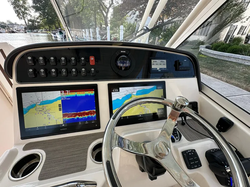 Slide: The Image of 2024 Grady-White Freedom 335 boat dashboard with navigation screens and controls. - 25