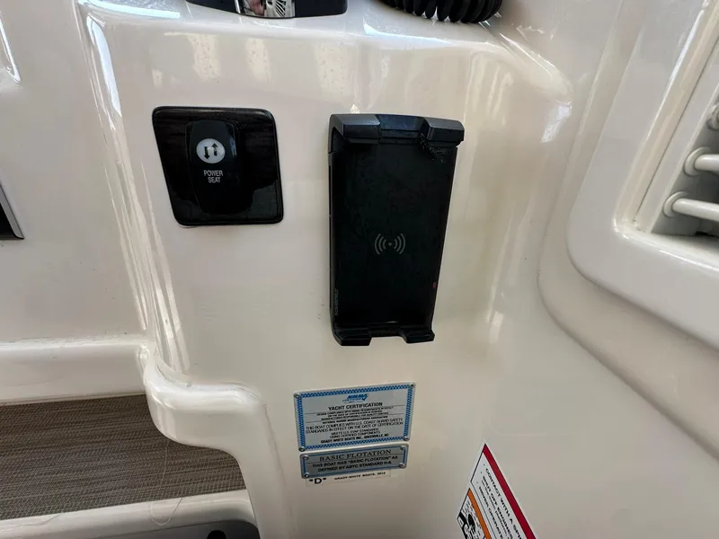 Slide: The Image of 2024 Grady-White Freedom 335 boat interior with power seat control and wireless charging pad. - 30