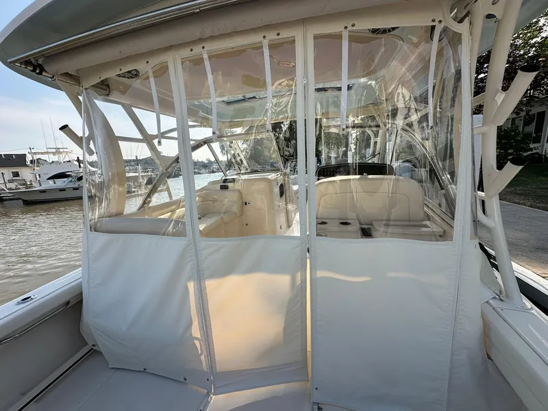 Slide: The Image of 2024 Grady-White Freedom 335 boat interior with clear enclosure, docked at marina. - 6