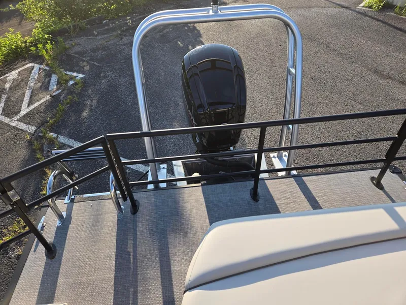 Slide: The Image of 2026 Starcraft EX22QDH boat with outboard motor and railing, parked on asphalt. - 9