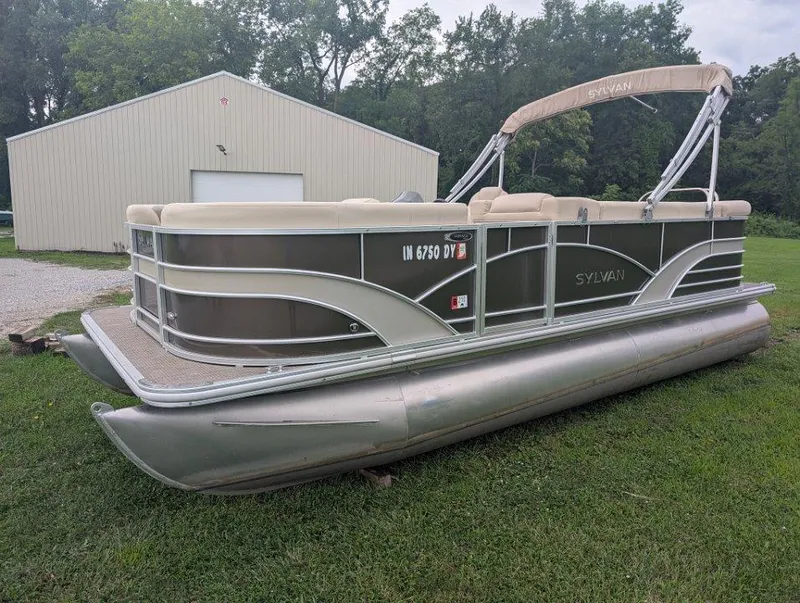 Slide: The Image of 2017 Sylvan Mirage Cruise 8520 CR pontoon boat on grass near a beige building. - 0