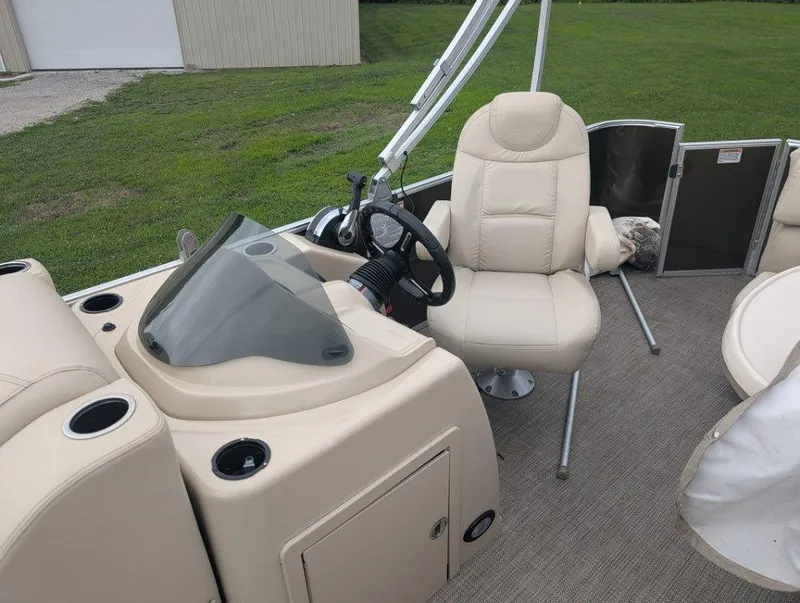 Slide: The Image of 2017 Sylvan Mirage Cruise 8520 CR boat interior with beige captain's chair and steering console. - 10