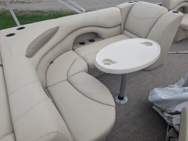 Slide: The Image of 2017 Sylvan Mirage Cruise 8520 CR boat interior with beige seating and a small table. - 4