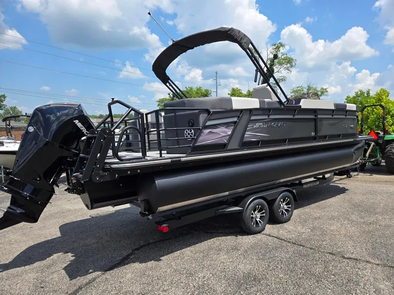 Slide: The Image of 2026 Starcraft SLS3R pontoon boat with Mercury engine on trailer, under blue sky. - 4