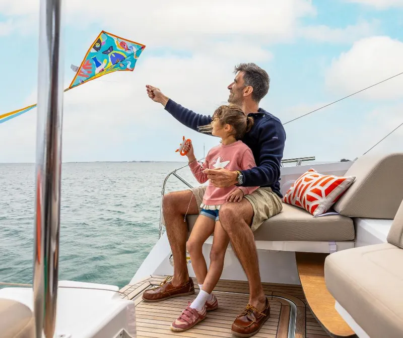 Slide: The Image of Father and daughter flying kite on 2025 Fountaine Pajot NEW 41 yacht. - 32