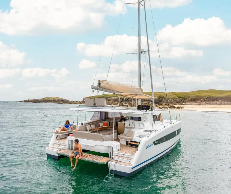 Slide: The Image of 2025 Fountaine Pajot NEW 41 catamaran sailing near a scenic beach. - 37