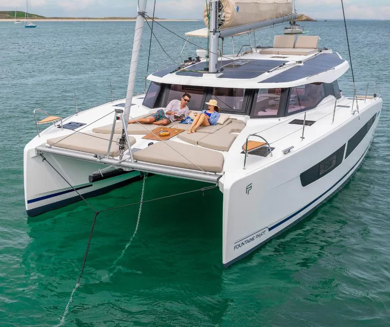 Slide: The Image of 2025 Fountaine Pajot NEW 41 catamaran with people relaxing on deck in calm waters. - 38