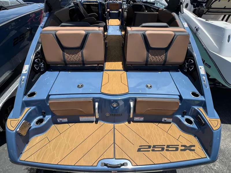 Slide: The Image of 2024 Yamaha Boats 255XD, blue exterior, luxury seating, and teak-style flooring. - 10