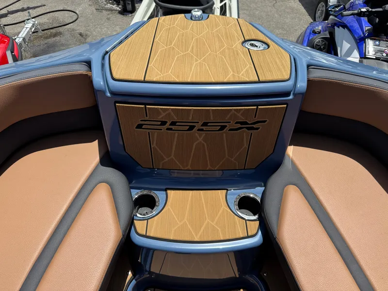 Slide: The Image of 2024 Yamaha Boats 255XD interior with wood accents and cup holders. - 14