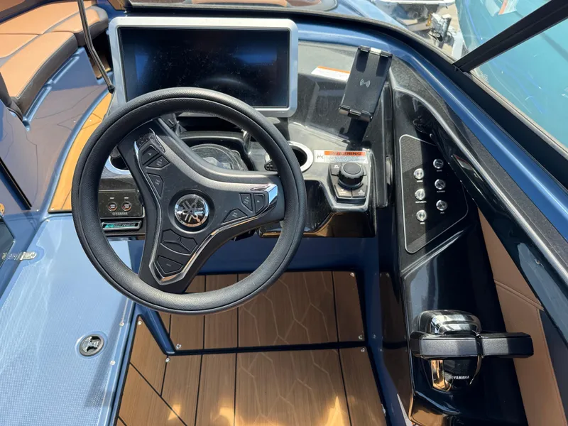 Slide: The Image of 2024 Yamaha Boats 255XD helm with steering wheel, touchscreen, and control panel. - 24