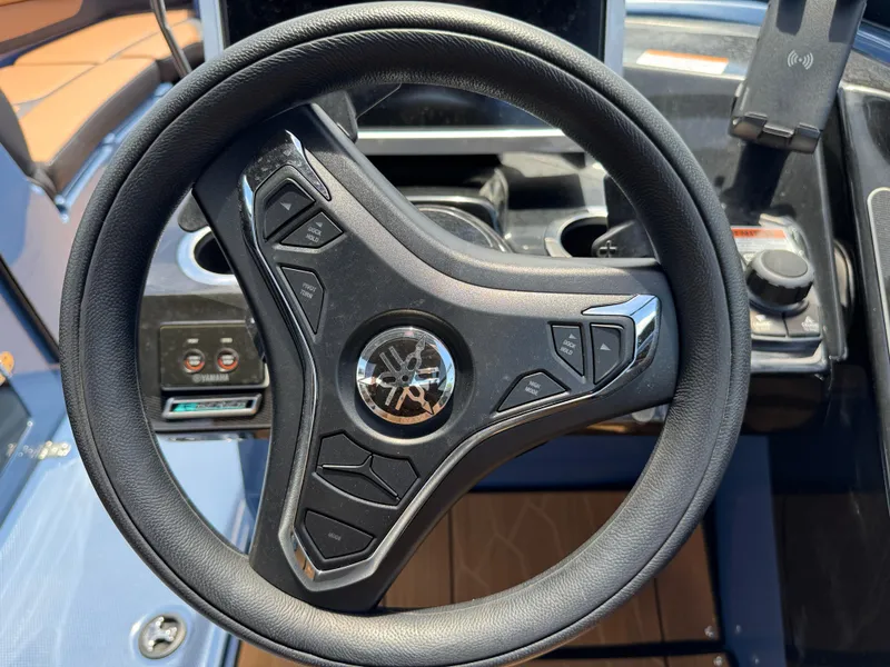 Slide: The Image of Steering wheel of 2024 Yamaha Boats 255XD with control buttons and logo. - 26