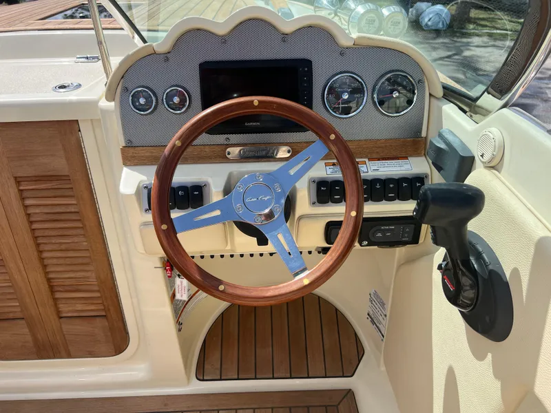 Slide: The Image of 2019 Chris-Craft Corsair 27 dashboard with wooden steering wheel and control panel. - 11