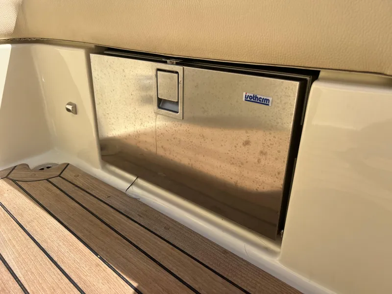 Slide: The Image of 2019 Chris-Craft Corsair 27 interior with Isotherm fridge and wooden flooring. - 17