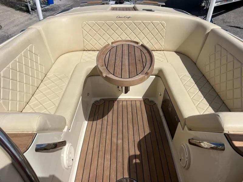 Slide: The Image of Luxurious 2019 Chris-Craft Corsair 27 boat interior with elegant seating and wooden table. - 18