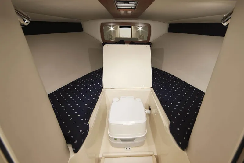 Slide: The Image of Manufacturer Provided Image: 2019 Chris-Craft Corsair 27 cabin interior with portable toilet and cushioned seating. - 24
