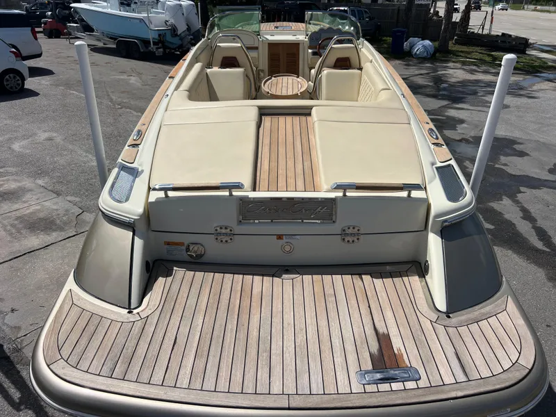 Slide: The Image of 2019 Chris-Craft Corsair 27 boat with elegant wood deck and beige seating. - 7