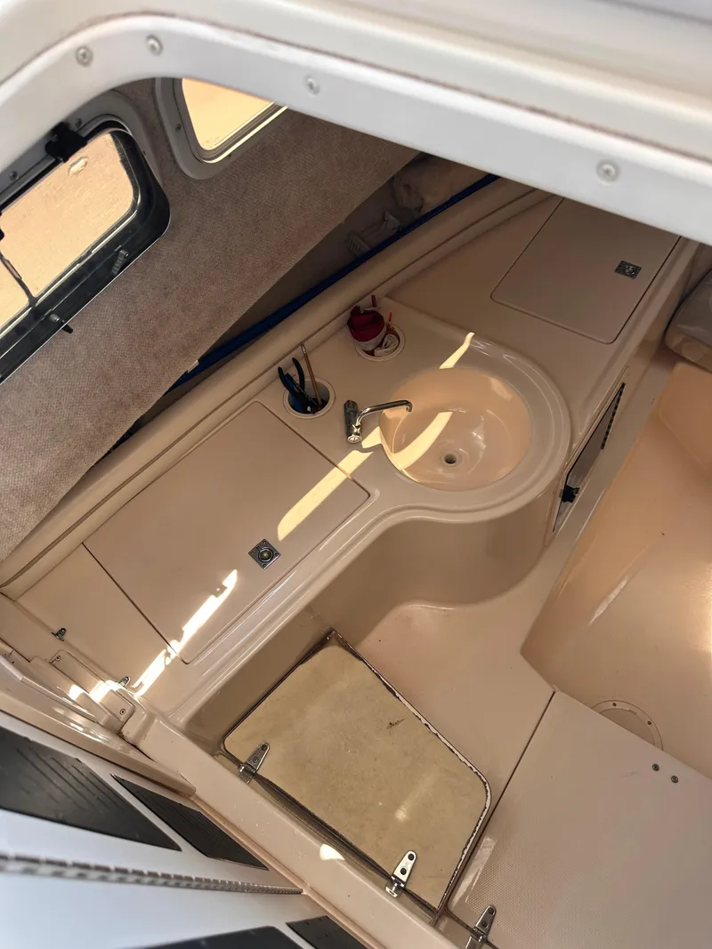 Slide: The Image of 2004 Grady-White Gulfstream 232 cabin interior with sink and storage area. - 12