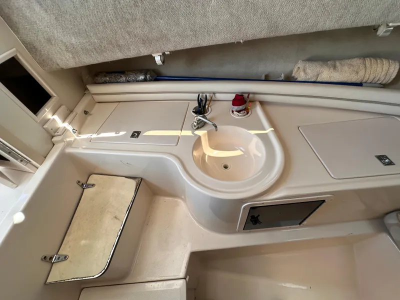 Slide: The Image of 2004 Grady-White Gulfstream 232 cabin interior with sink and storage compartments. - 13
