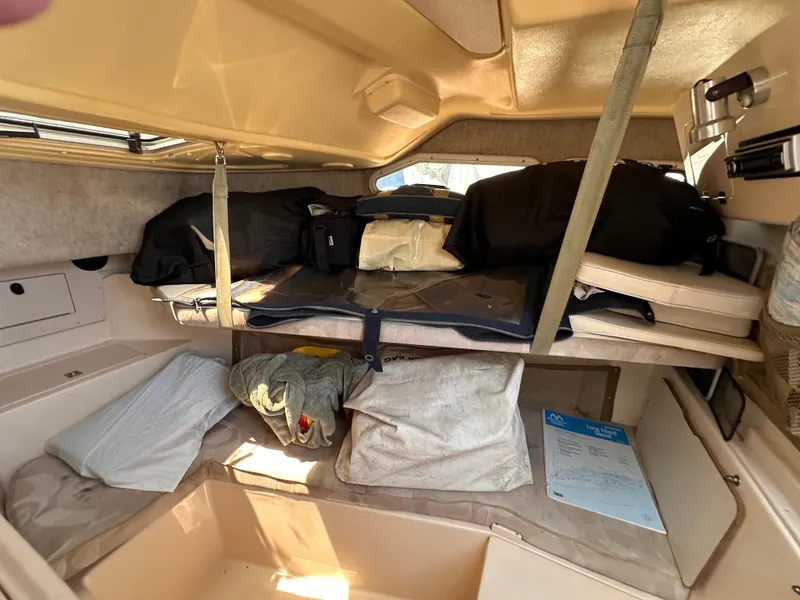 Slide: The Image of 2004 Grady-White Gulfstream 232 cabin interior with storage compartments and bedding. - 15