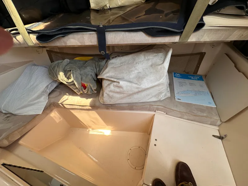 Slide: The Image of 2004 Grady-White Gulfstream 232 cabin interior with storage and bedding. - 16